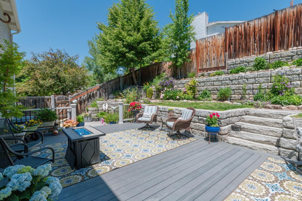 Wooden deck with an outdoor fire pit and a fenced backyard