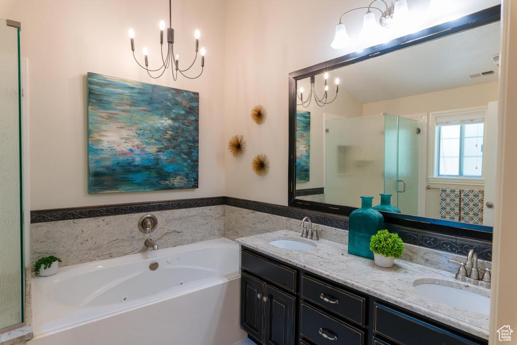 Bathroom with a chandelier, a shower stall, double vanity, and a whirlpool tub