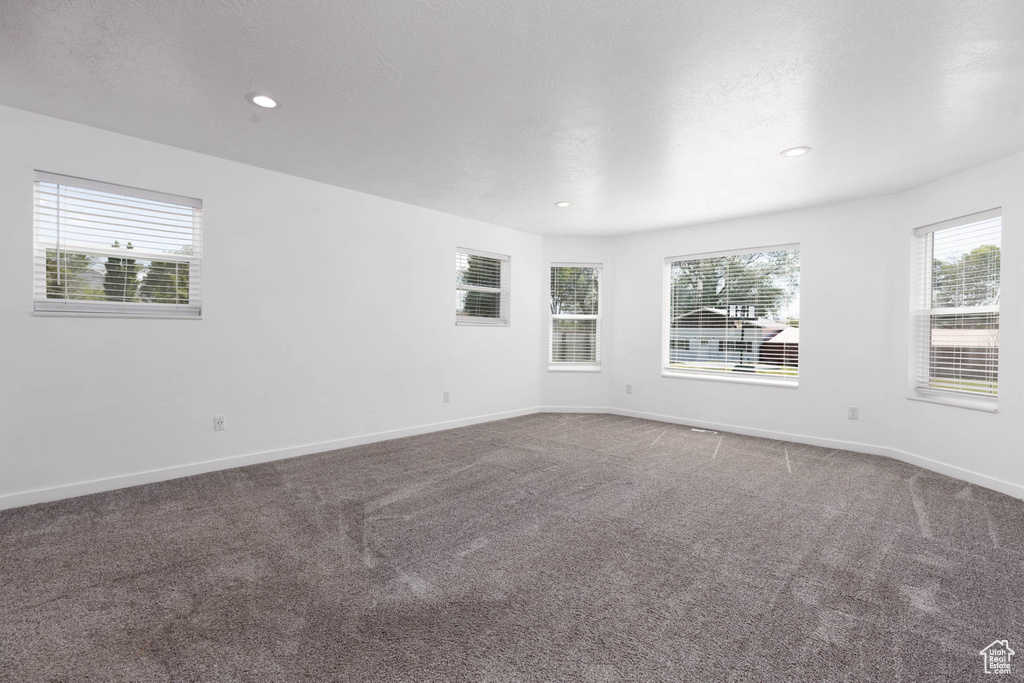 Carpeted spare room with baseboards and recessed lighting