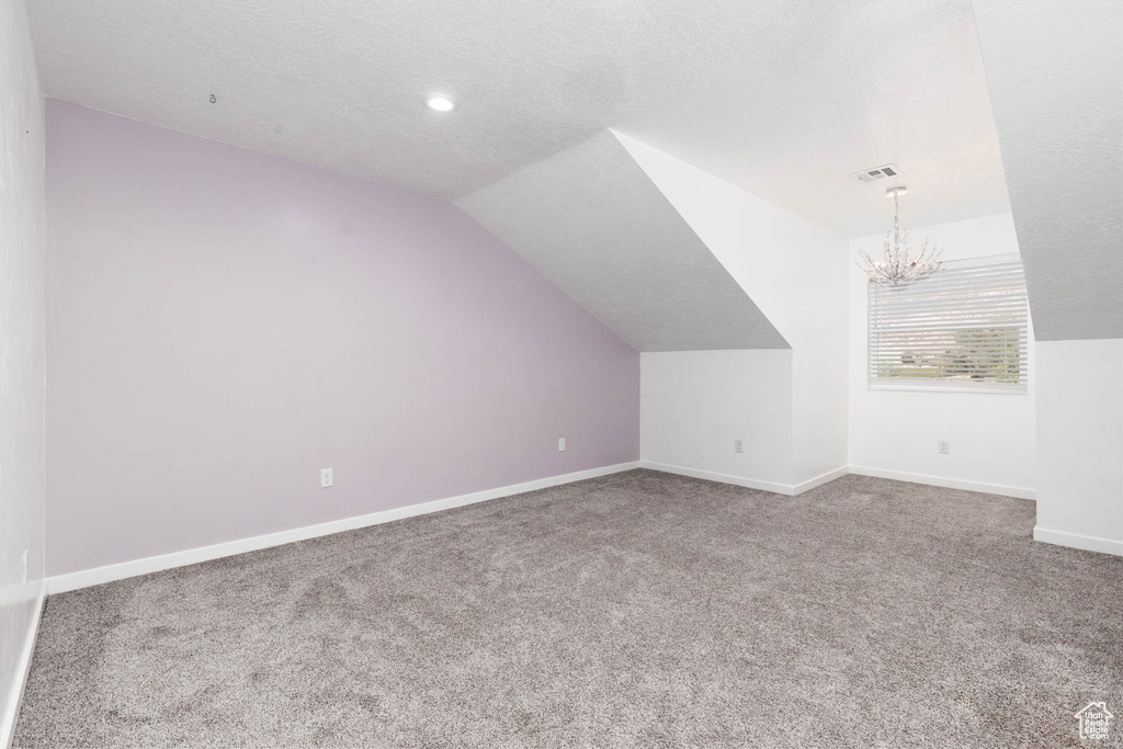 Bonus room with carpet flooring, a chandelier, baseboards, vaulted ceiling, and recessed lighting