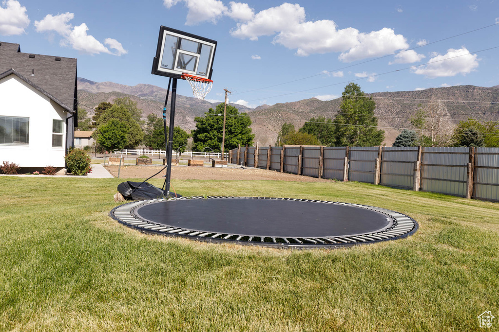 View of yard featuring a trampoline and a mountain view
