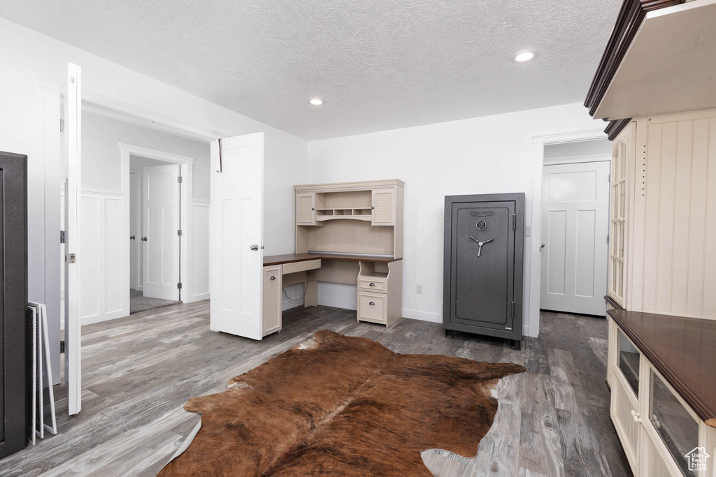 Office space with wood finished floors, a textured ceiling, recessed lighting, and baseboards