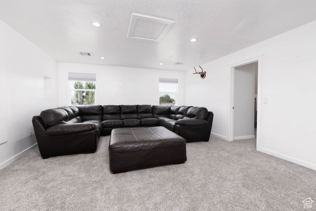 Carpeted living room with attic access, recessed lighting, and baseboards