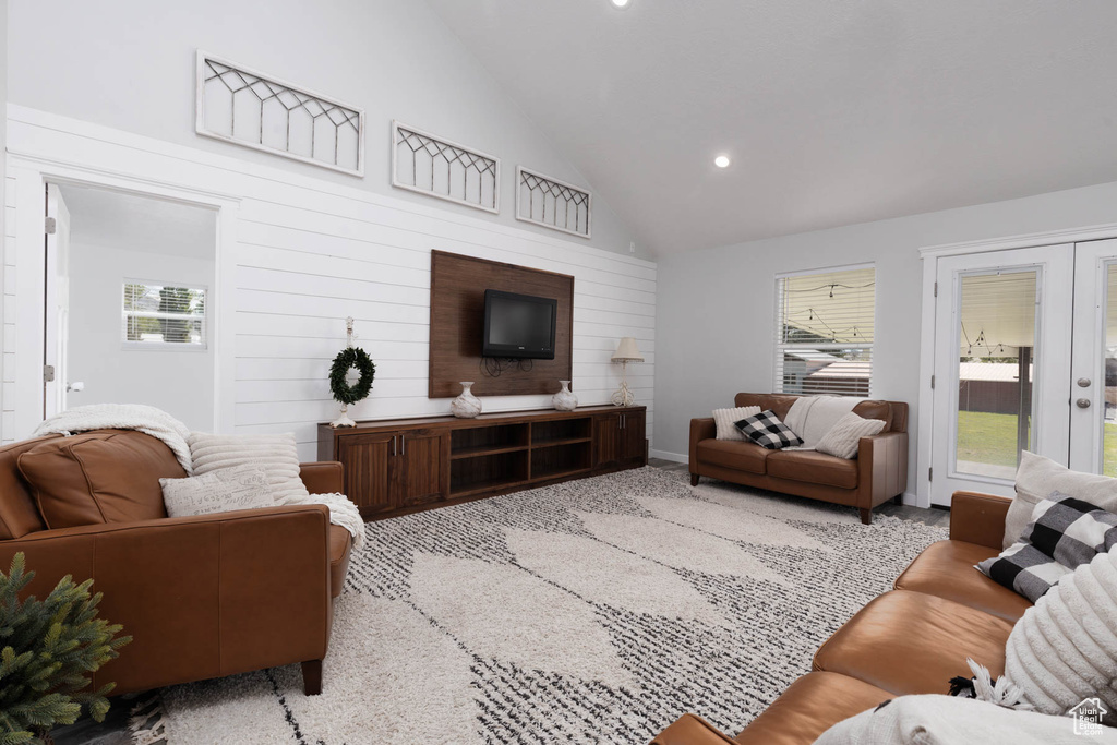 Living room with healthy amount of natural light, recessed lighting, high vaulted ceiling, and carpet