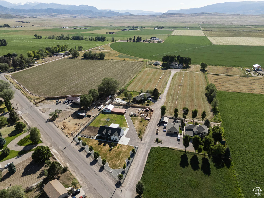 Aerial view of property and surrounding area with rural landscape, extensive farmland, and a mountainous background