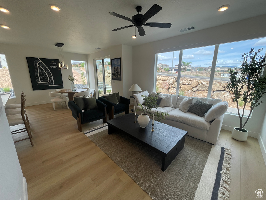 Living area featuring light wood-type flooring, baseboards, recessed lighting, and ceiling fan