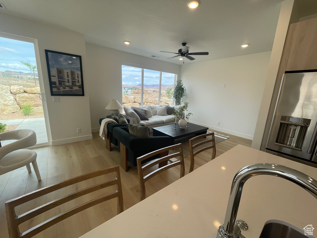 Living room with baseboards, ceiling fan, wood finished floors, and recessed lighting