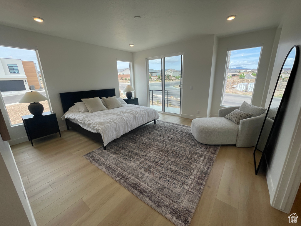 Bedroom featuring access to outside, multiple windows, light wood-style flooring, recessed lighting, and baseboards