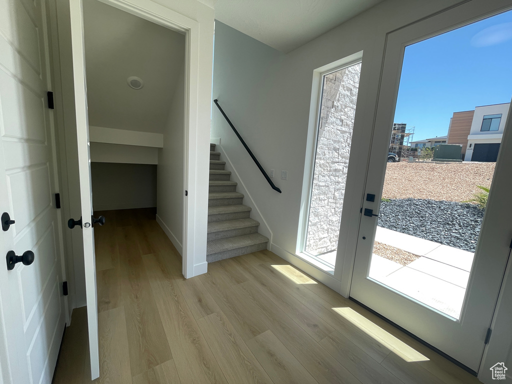 Foyer featuring light wood finished floors, stairway, and baseboards