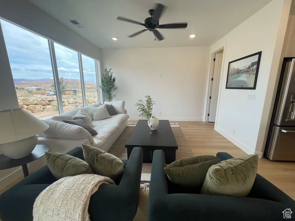 Living area with light wood finished floors, ceiling fan, recessed lighting, and baseboards
