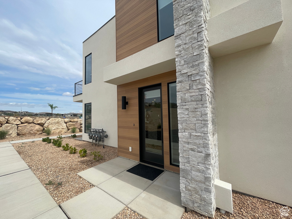Doorway to property with stucco siding and a patio
