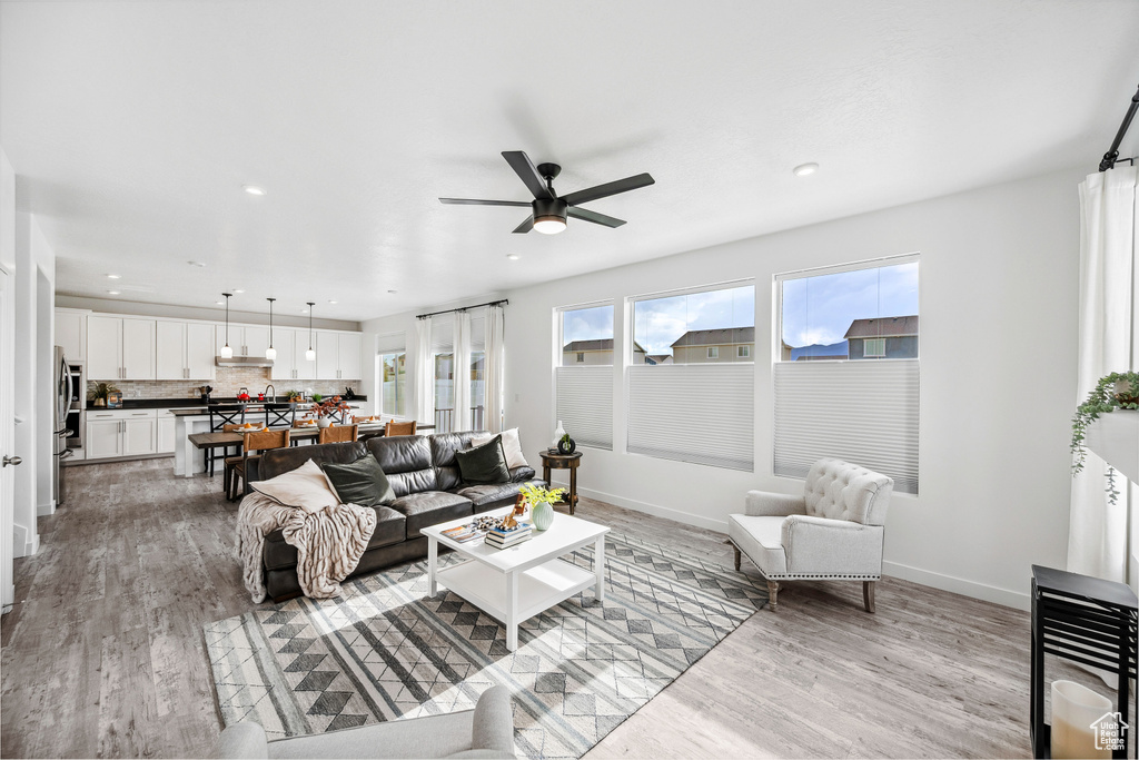 Living area featuring ceiling fan, light wood-type flooring, baseboards, and recessed lighting