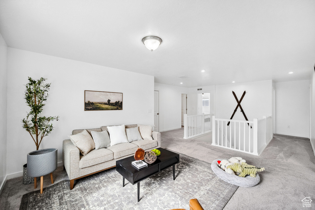 Carpeted living area featuring recessed lighting and baseboards