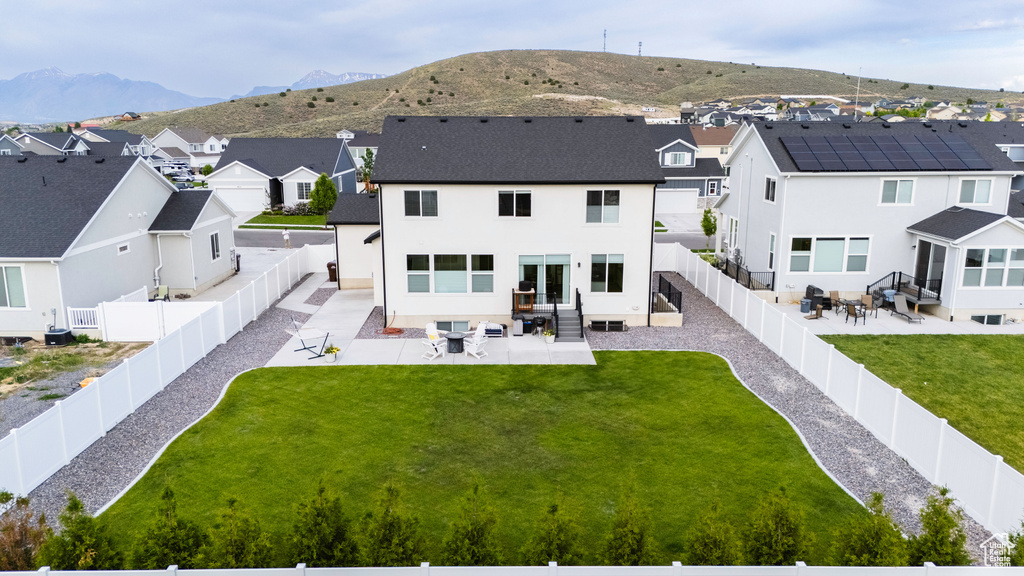 Back of house featuring a residential view, a patio, a mountain view, and stucco siding