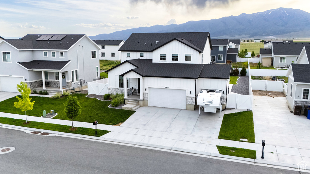 Modern farmhouse style home featuring a gate, board and batten siding, stone siding, and a residential view