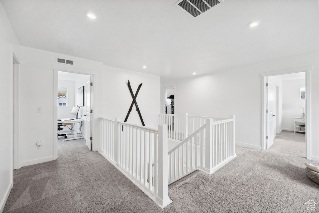 Hall with an upstairs landing, carpet flooring, an office area, recessed lighting, and baseboards