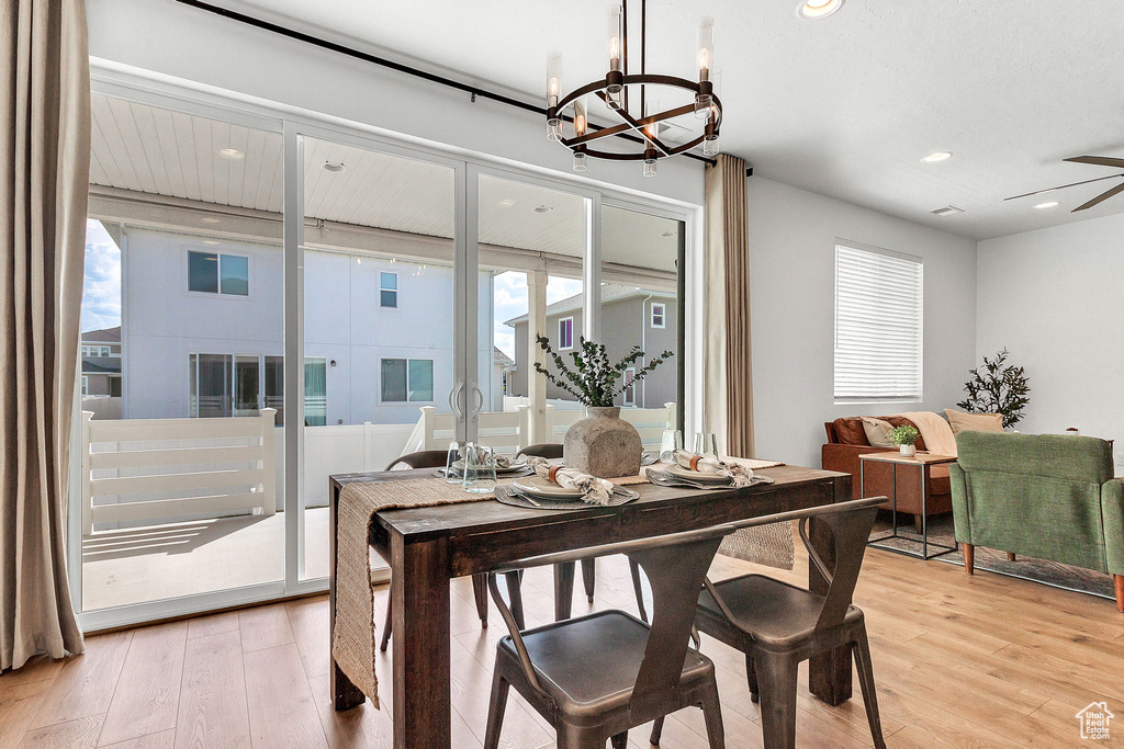 Dining room with light wood finished floors, a chandelier, plenty of natural light, and recessed lighting