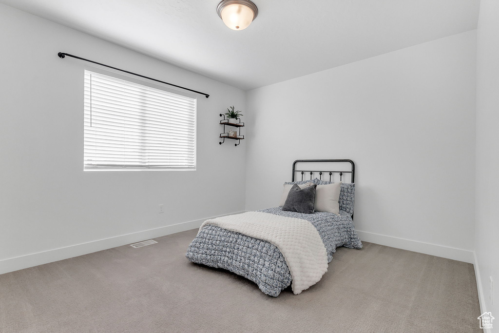Bedroom featuring carpet floors and baseboards