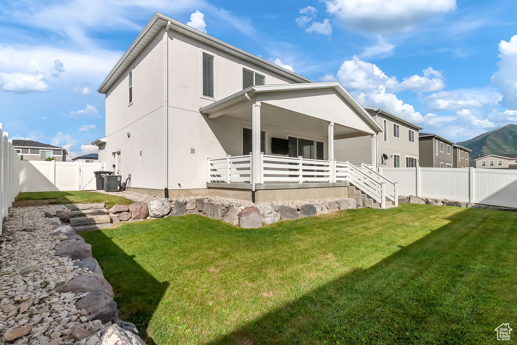 Back of house with central AC and stucco siding