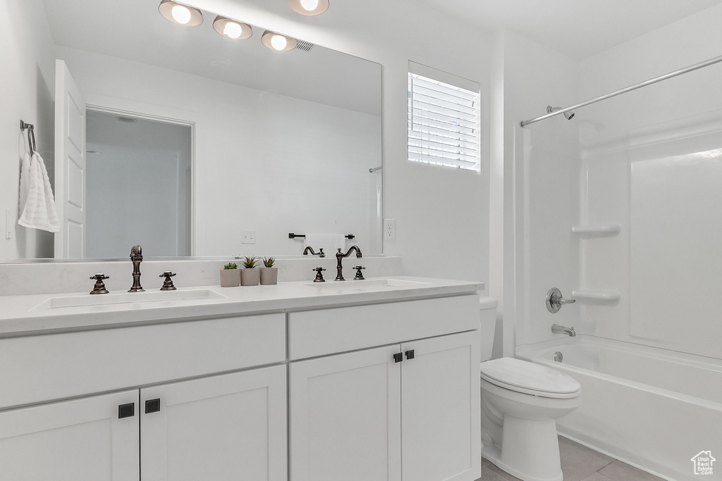 Bathroom with double vanity, toilet, washtub / shower combination, and tile patterned floors