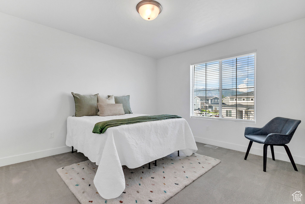 Bedroom featuring carpet and baseboards