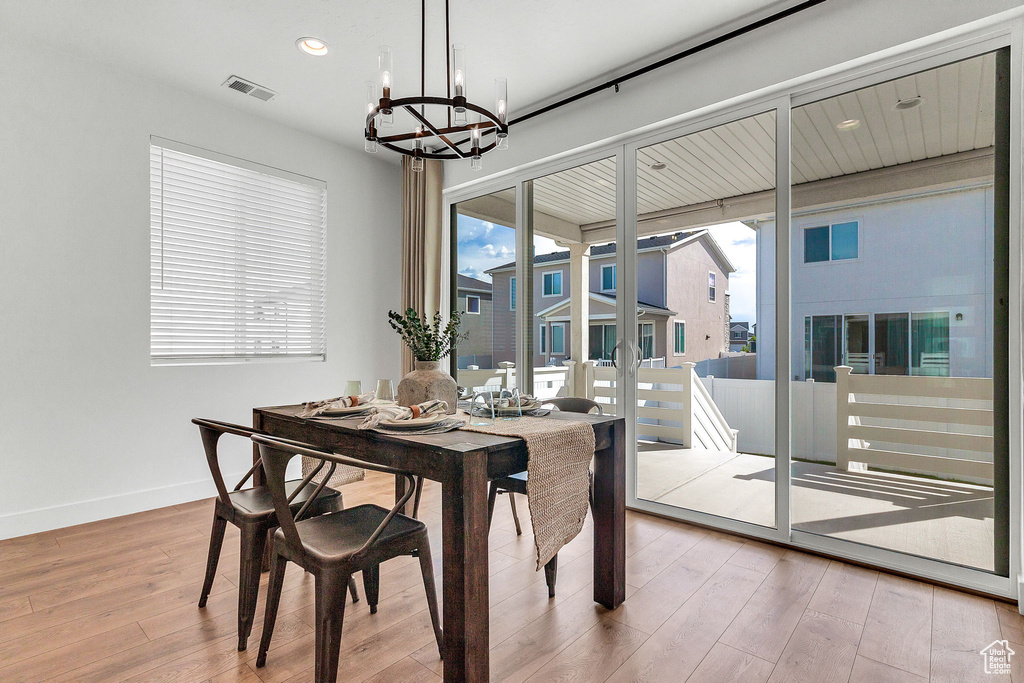 Dining space with a chandelier, light wood-style flooring, recessed lighting, and baseboards