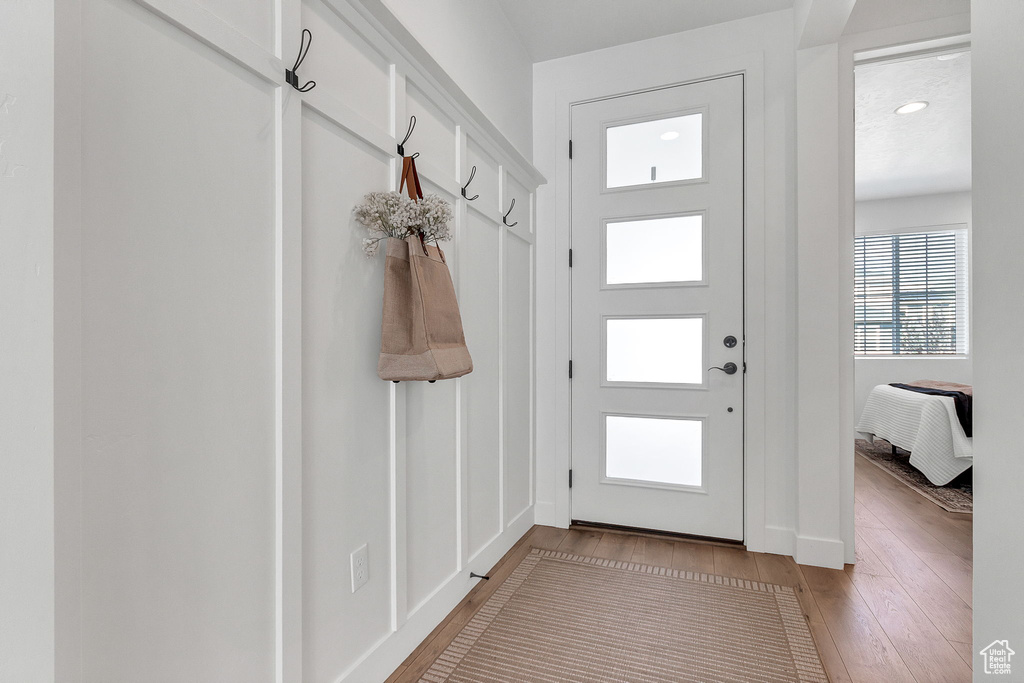 Mudroom featuring light wood finished floors and baseboards