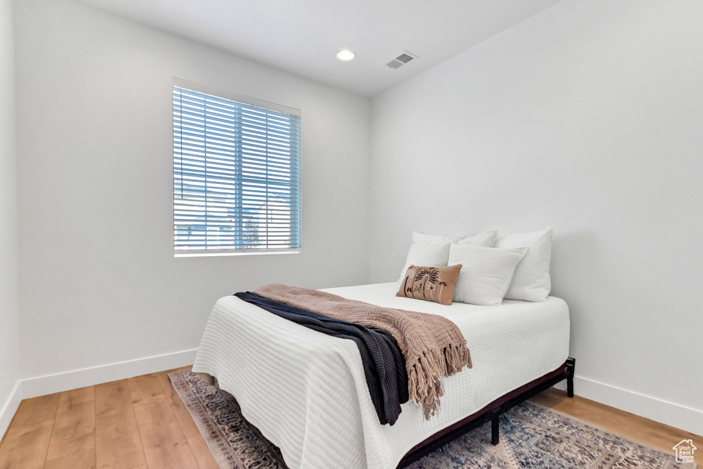 Bedroom with baseboards, wood finished floors, and recessed lighting