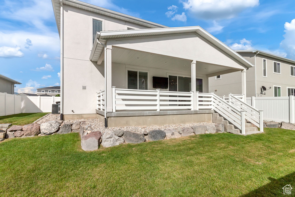 View of front facade featuring cooling unit, covered porch, and stucco siding