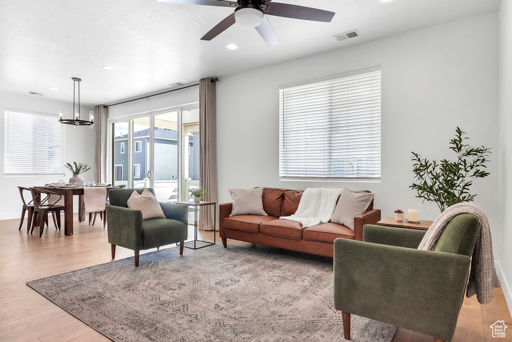 Living room featuring a chandelier, light wood-style flooring, recessed lighting, and ceiling fan