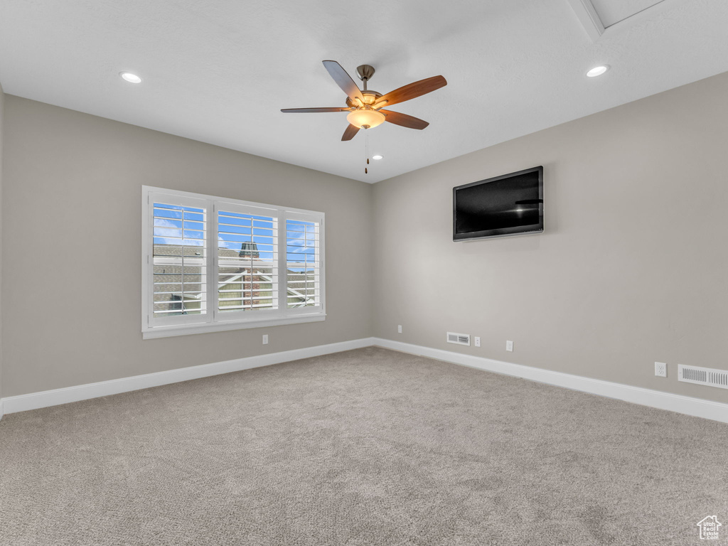 Carpeted spare room featuring ceiling fan, baseboards, and recessed lighting