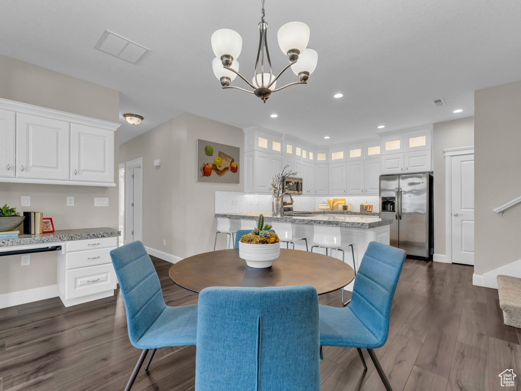 Dining space featuring baseboards, dark wood-style flooring, a chandelier, and recessed lighting