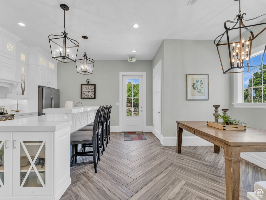 Dining area featuring a chandelier, baseboards, healthy amount of natural light, and recessed lighting