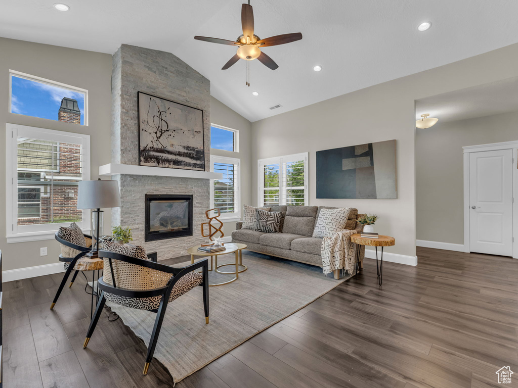 Living room with high vaulted ceiling, a ceiling fan, wood finished floors, baseboards, and a fireplace