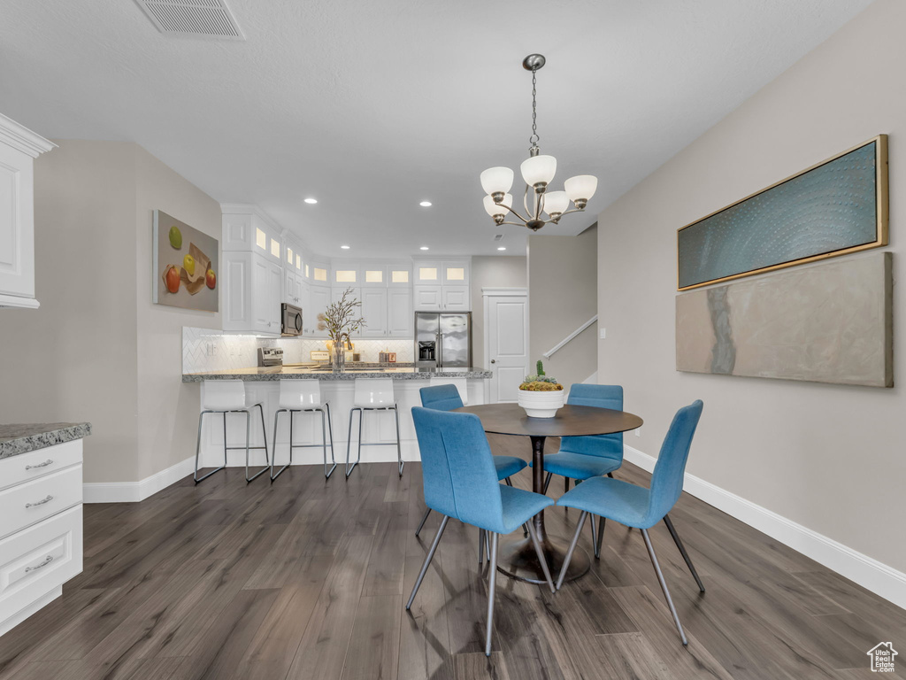 Dining room with baseboards, recessed lighting, a chandelier, and dark wood-style floors