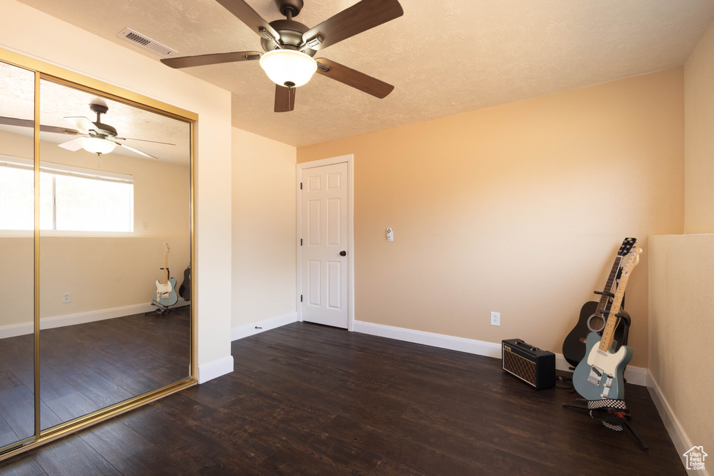 Empty room with ceiling fan, wood finished floors, and baseboards