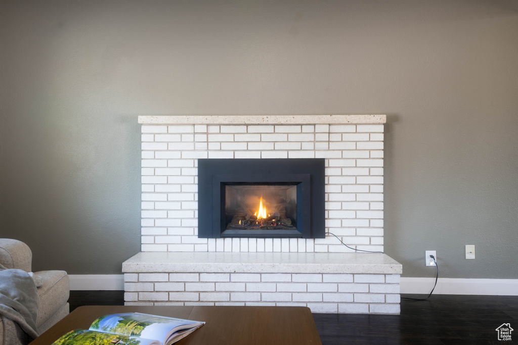 Detailed view of baseboards, wood finished floors, and a fireplace