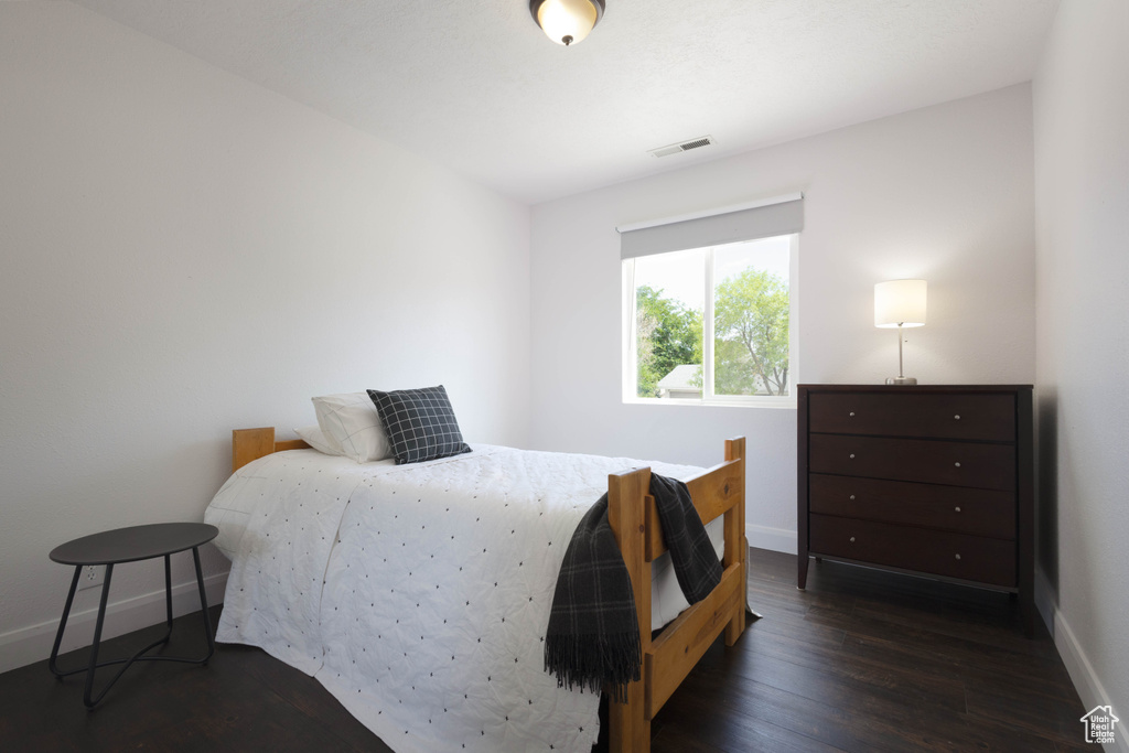 Bedroom with baseboards and dark wood-style floors