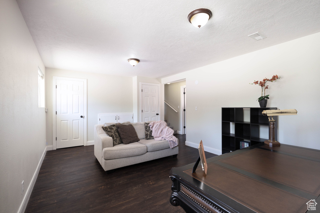 Living room with dark wood-style floors and baseboards