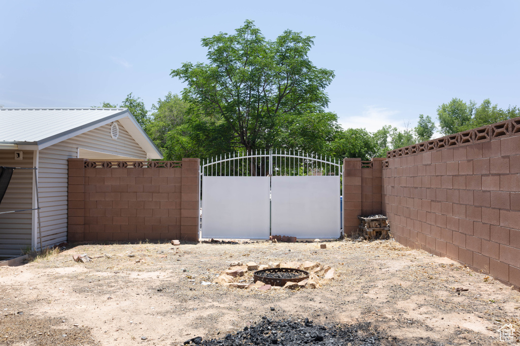 View of yard featuring a gate and a fire pit