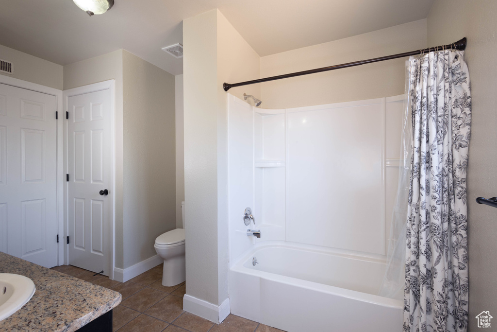 Bathroom featuring shower / tub combo with curtain, vanity, toilet, baseboards, and tile patterned floors