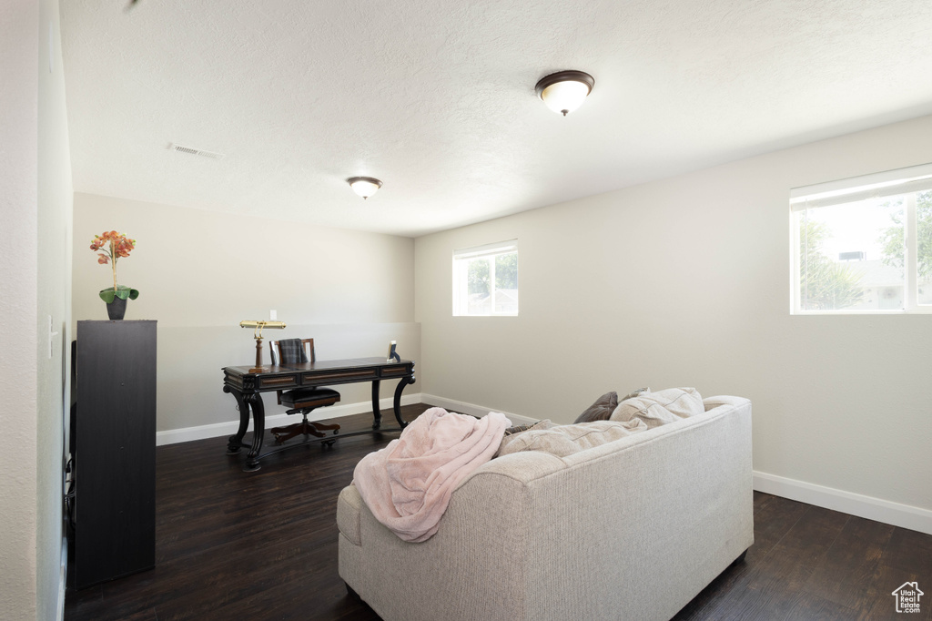 Living room featuring dark wood finished floors and baseboards