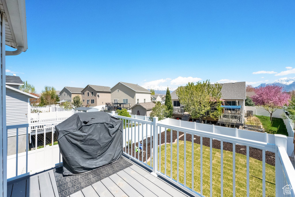 Wooden terrace featuring a residential view and area for grilling