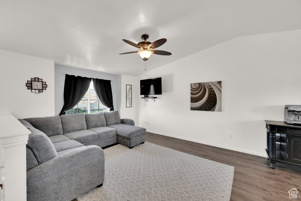 Living room featuring wood finished floors, a ceiling fan, lofted ceiling, and baseboards