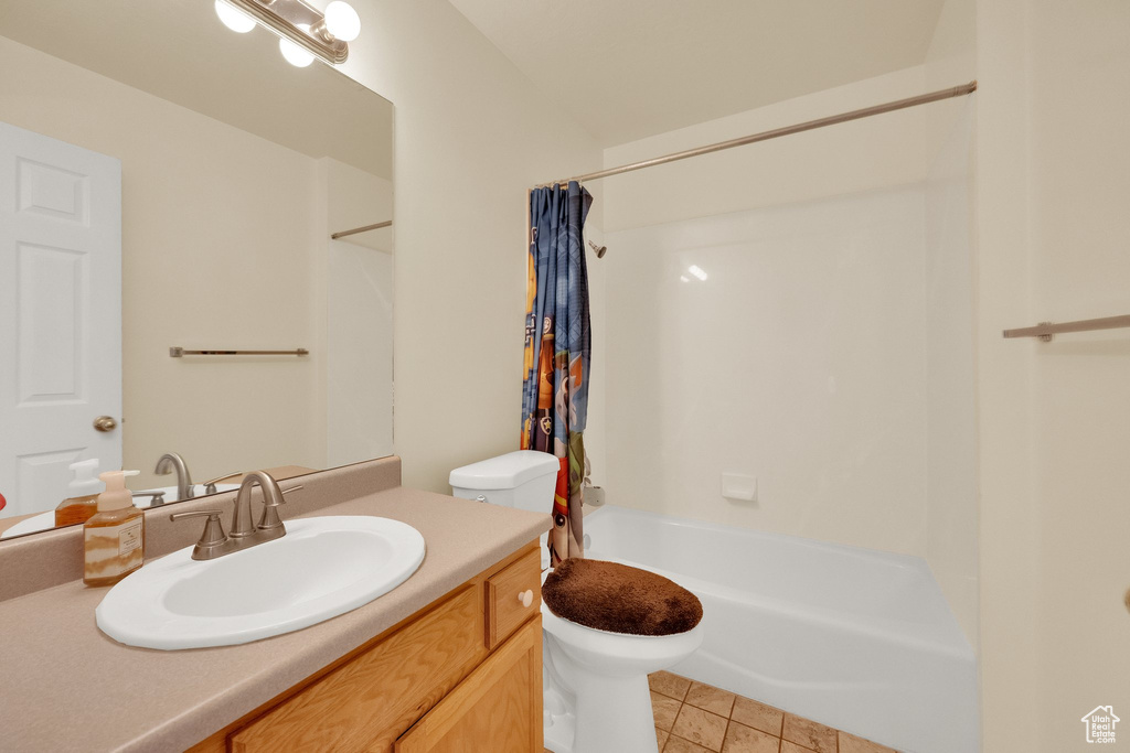 Bathroom with toilet, vanity, shower / tub combo, and tile patterned flooring