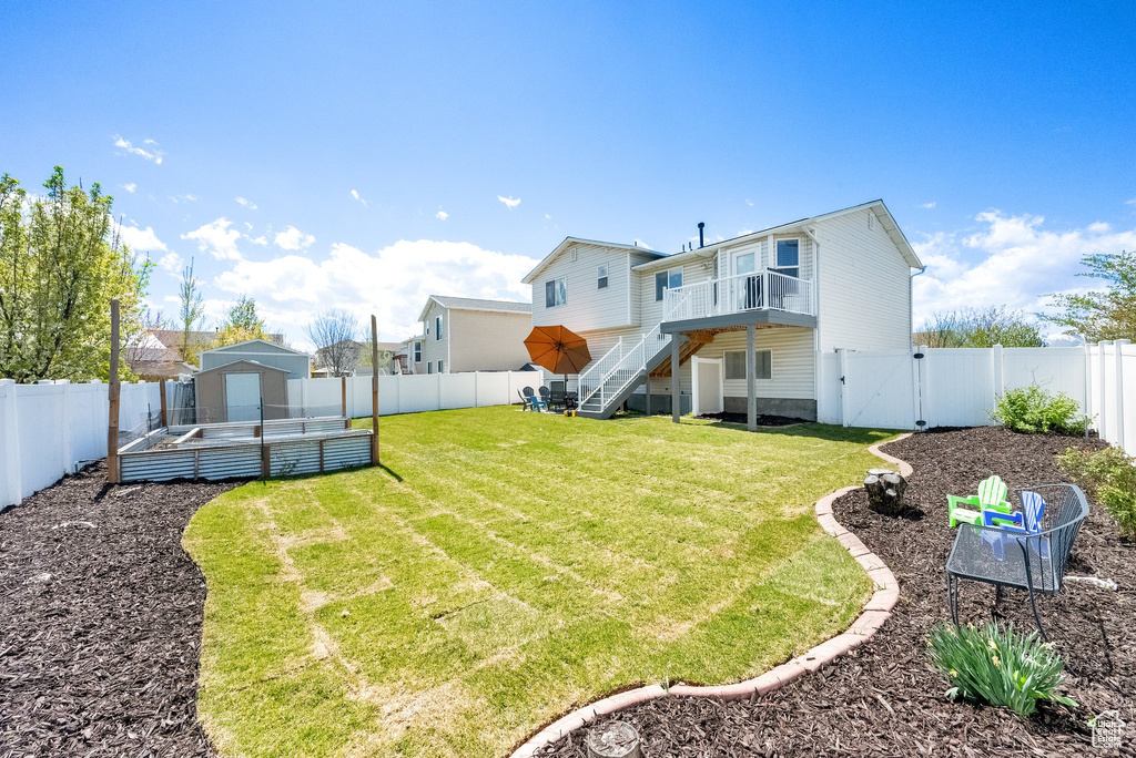 View of yard featuring a gate, a wooden deck, and stairs