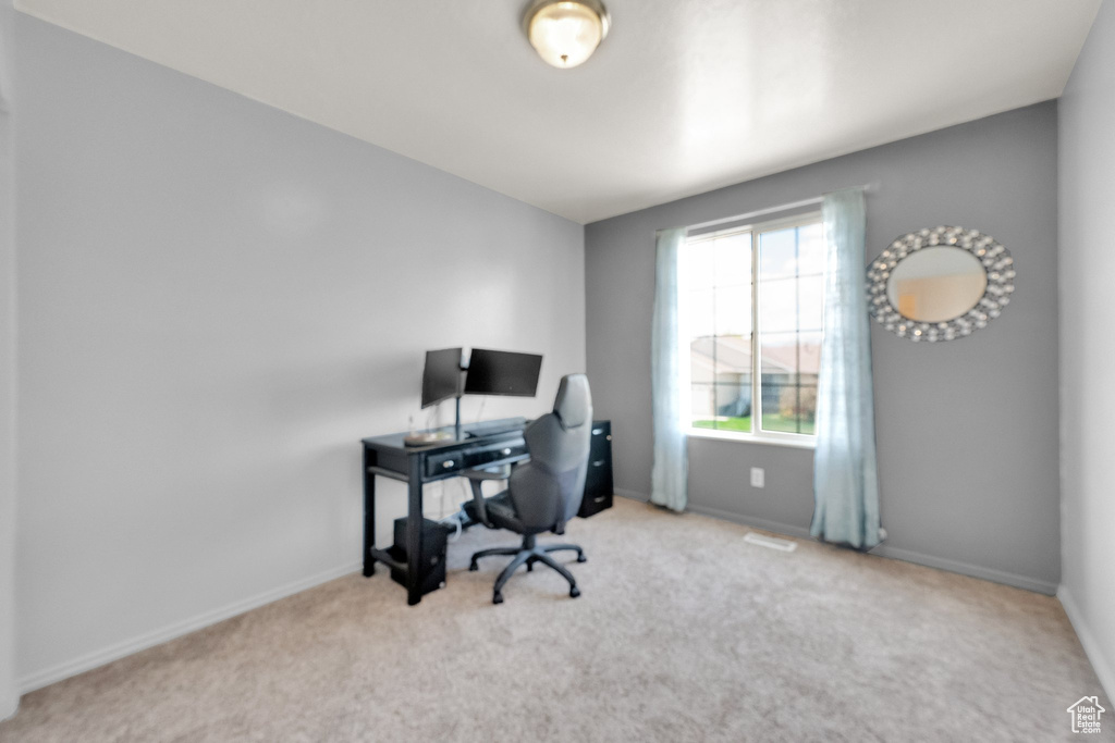 Carpeted office with healthy amount of natural light and baseboards