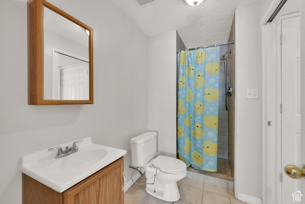 Bathroom with vanity, tile patterned flooring, toilet, baseboards, and a shower with shower curtain