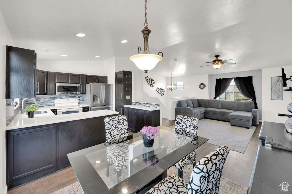 Dining room featuring light wood-type flooring, a ceiling fan, and recessed lighting