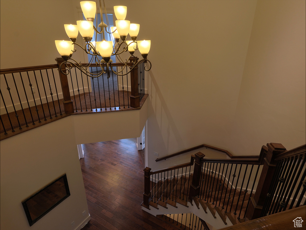 Stairs featuring a chandelier and wood finished floors